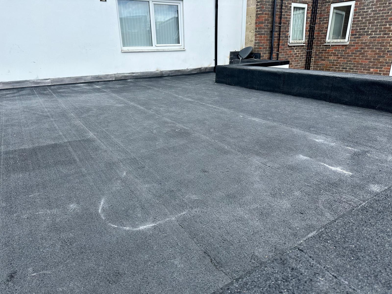 Completed torch-on felt flat roof on a Hampshire residential extension with neat lead upstand detailing