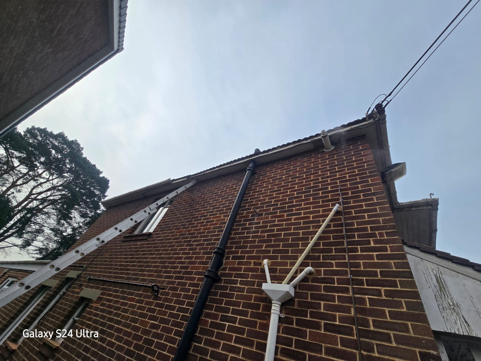 Gable end view showing new UPVC fascia, soffit and black half-round guttering fitted to a Hampshire semi-detached house