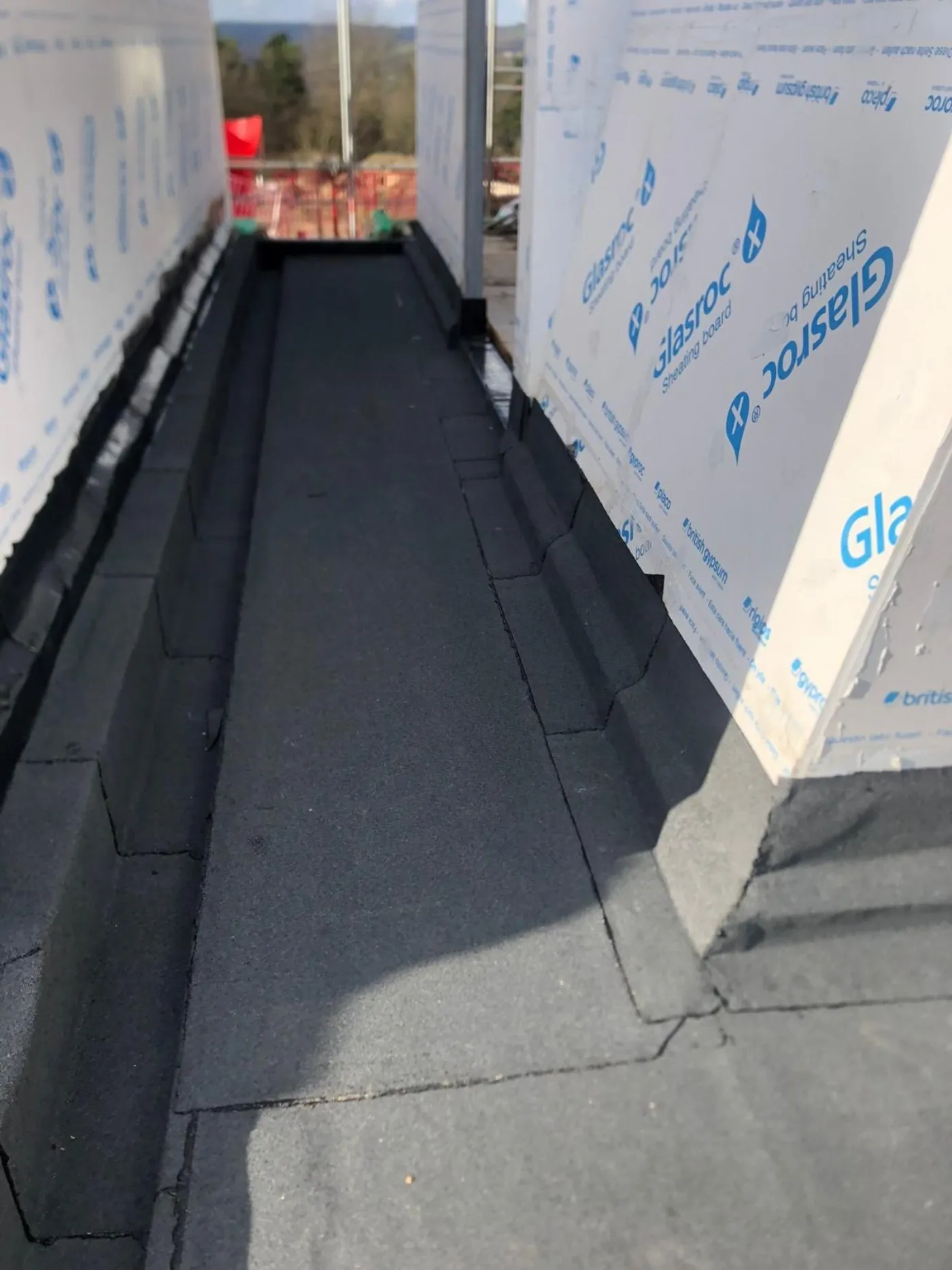 Commercial torch-on felt flat roof installation between parapets in Portsmouth