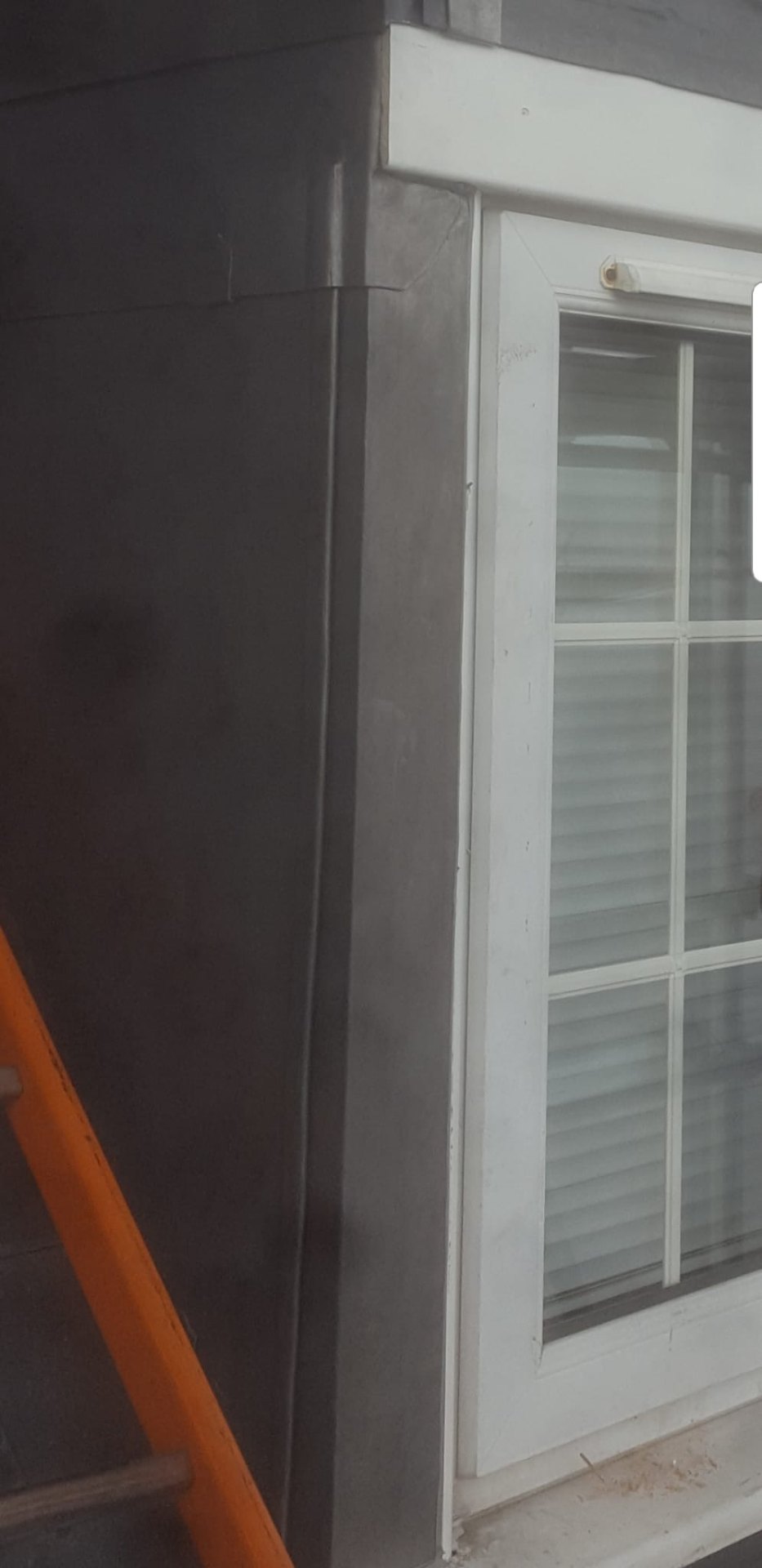 Vertical lead cladding and corner detailing around a dormer window on a coastal Hampshire home
