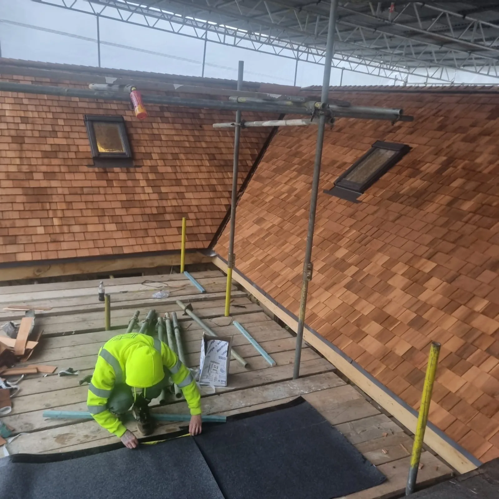Roofer repairing slipped clay tiles on a Hampshire pitched roof
